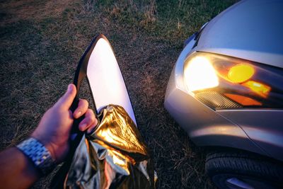 Close-up of hand holding diffuser by car