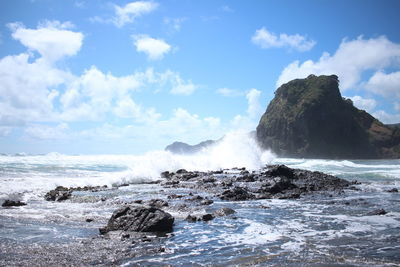 Scenic view of rocks in sea against sky