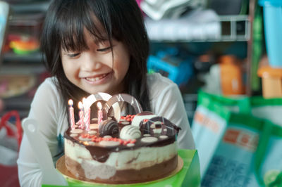 Smiling girl looking at cake