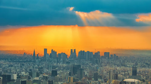 Aerial view of buildings in city during sunset