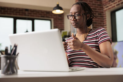 Young woman using laptop at table