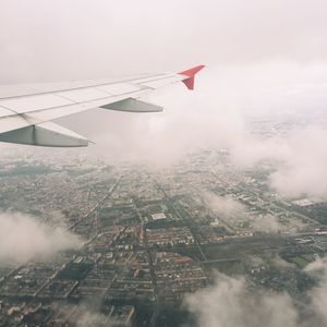 Aerial view of airplane wing over cityscape