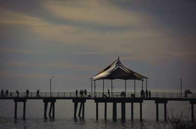 Silhouette pier on sea against sky at sunset
