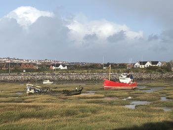 Boats moored on shore against sky