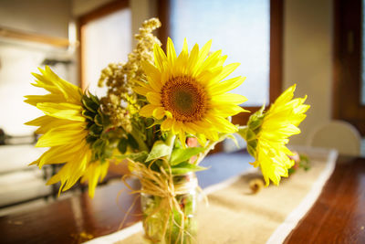 Close-up of yellow flower vase on table at home