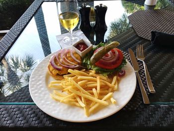 High angle view of burger and french fries in plate on table