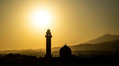 Silhouette building against sky during sunset