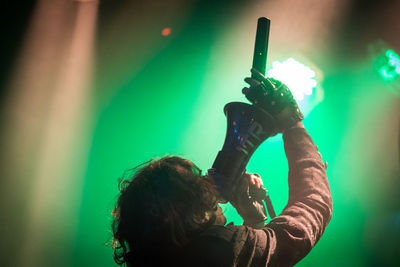 Rear view of woman photographing illuminated light