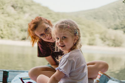 Little girl with mother on a lake