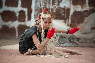 Woman with plants dancing on footpath