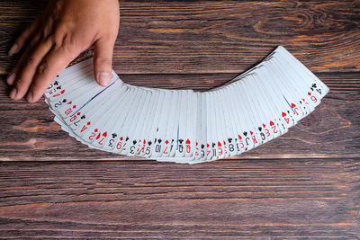 Cropped hand playing poker at table