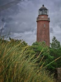 Lighthouse by sea against sky