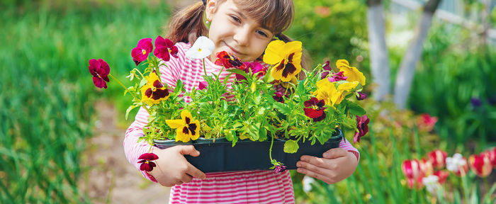 Smiling girl embracing flowers