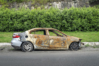 Abandoned burnt car remains on the side of the road