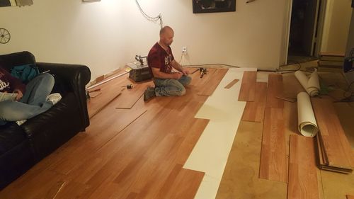 Man sitting on hardwood floor at home