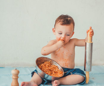 Shirtless baby boy eating food