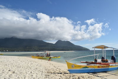 Panoramic view of boats moored on beach against sky