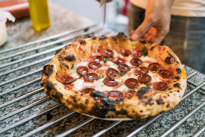 Cropped hand of person holding pizza