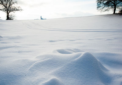 Snow covered land against sky