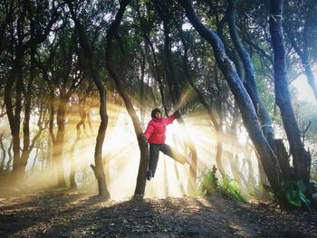 Man standing amidst trees in forest