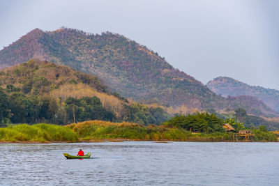 Scenic view of river and mountains against sky