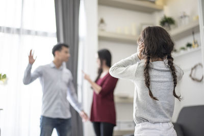 Daughter looking at parents fighting in house