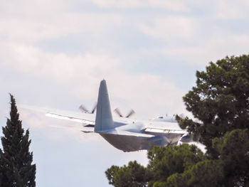 Low angle view of airplane flying against sky