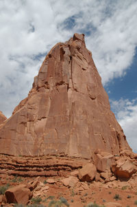 Low angle view of rock formation against cloudy sky