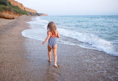 Full length of girl standing on beach