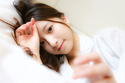 Portrait of woman lying down on bed