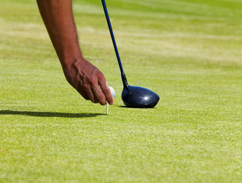 Low section of person playing golf on field