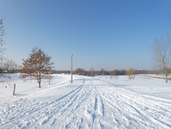 Snow covered field against clear sky