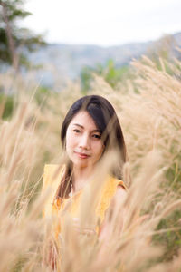 Portrait of beautiful young woman in field