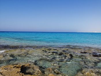 Scenic view of sea against clear blue sky