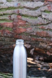 Close-up of small bottle against wall