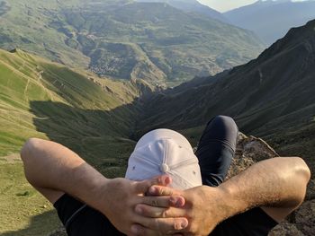 Low section of man relaxing on mountains