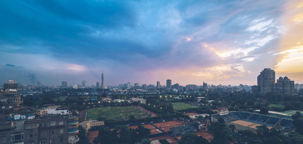 Aerial view of city against cloudy sky