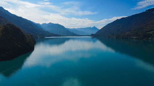 Scenic view of lake by mountains against sky