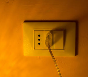 Low angle view of electric lamp on wall at home