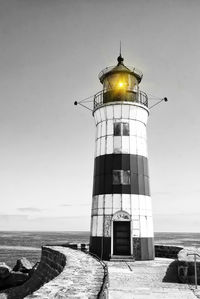 Low angle view of illuminated lighthouse against sky at port maasholm