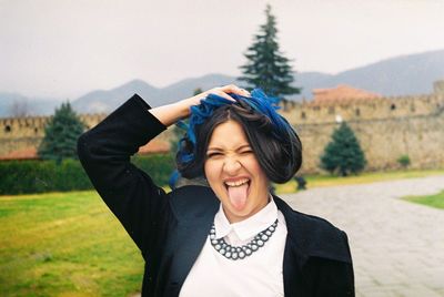 Portrait of smiling young woman standing in park