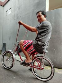 Side view of young man riding bicycle