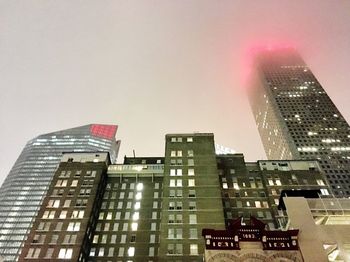 Low angle view of skyscrapers against sky at night