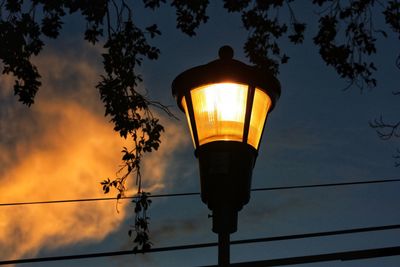 Low angle view of illuminated street light against sky