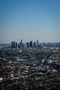 Aerial view of buildings in city against clear sky