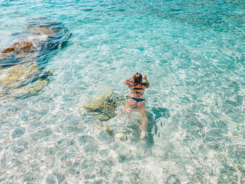 Young woman swimming in transparent water. sea, summer, beach.