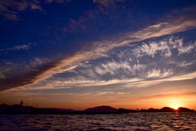 Scenic view of sea against dramatic sky during sunset