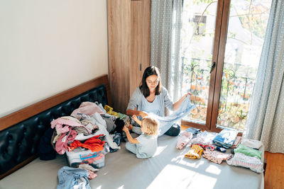 High angle view of daughter helping mother at chores