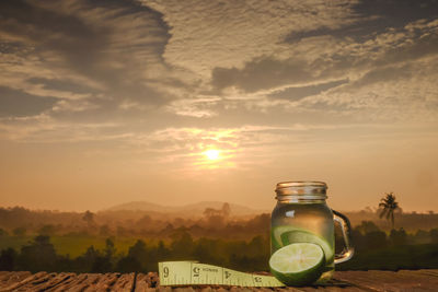 Wine glass against sky during sunset