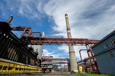 Low angle view of smoke stack against sky at factory